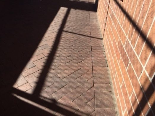 Shadow of a fence on a brick wall